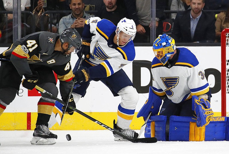 St. Louis Blues goalie Jake Allen, right, blocks a shot by Vegas Golden Knights right wing Pierre-Edouard Bellemare, left, during the third period of an NHL hockey game Saturday, Oct. 21, 2017, in Las Vegas. Blues defenseman Carl Gunnarsson is in the middle. 