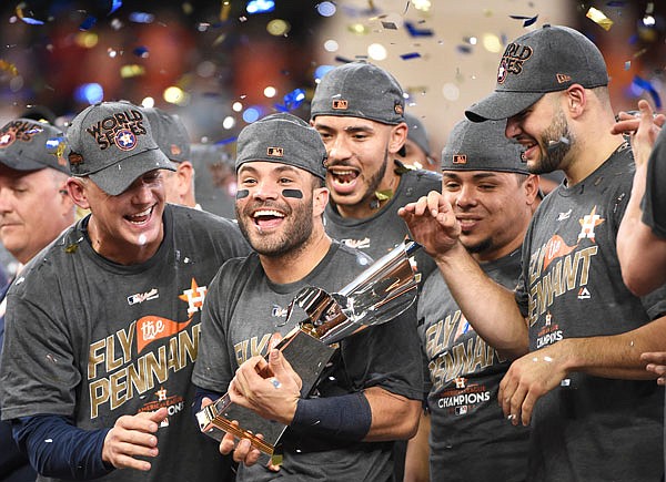 Astros second baseman Jose Altuve holds up the trophy Saturday after Game 7 of the American League Championship Series against the Yankees in Houston. The Astros won 4-0 to win the series.