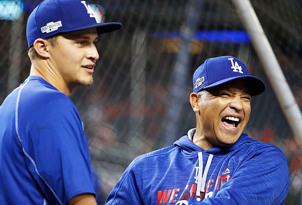 In this Oct. 13, 2016, file photo, Dodgers manager Dave Roberts (right) jokes with shortstop Corey Seager during batting practice before Game 5 of the National League Division Series against the Nationals at Nationals Park in Washington.