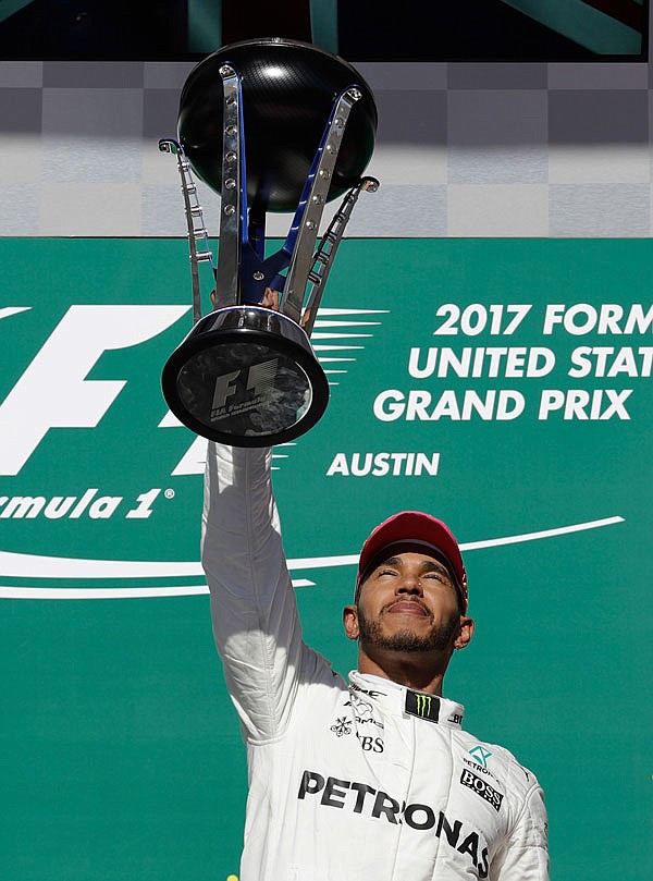 Mercedes driver Lewis Hamilton lifts his trophy after winning Sunday's Formula One U.S. Grand Prix race at the Circuit of the Americas in Austin, Texas.