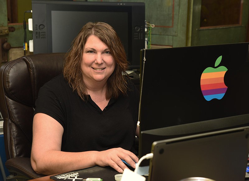 Holly Stitt sits in front of a computer inside her Capitol Avenue office, from which she and her husband run their software business, her creative imagery business and Avenue HQ with business partner, Quinten Rice.