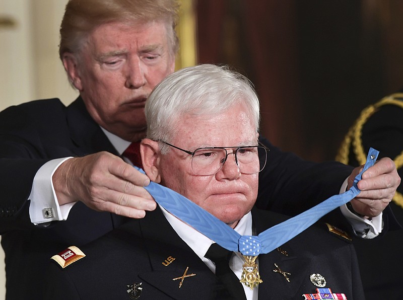 President Donald Trump bestows the nation's highest military honor, the Medal of Honor, on retired Army Capt. Gary M. Rose on Monday during a ceremony in the East Room of the White House in Washington.

