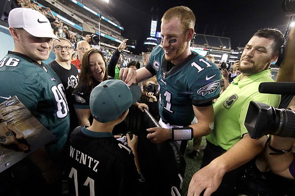 Eagles quarterback Carson Wentz talks to relatives of Lukas Kusters, a young boy who lost his battle with cancer, after Monday night's game against the Redskins in Philadelphia. The Eagles won 34-24.