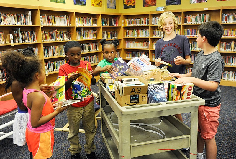 Children from Thorpe J. Gordon Elementary School look at the books that Louis Gerling and Tracy Morrow are donating to those affected by Hurricane Harvey while in the school library in Jefferson City on Tuesday, August 29, 2017. 