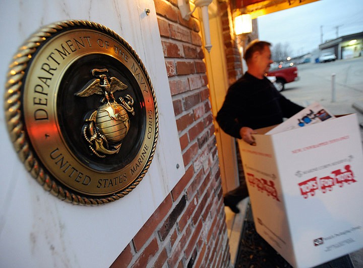 Steve Diemler, serving as Toys for Tots coordinator for Marine Corps League, Samuel F. Gearhart Detachment, carries a box filled with donated toys and goods to a delivery truck in December 2014 as members of the Salvation Army pick up toys and donations.