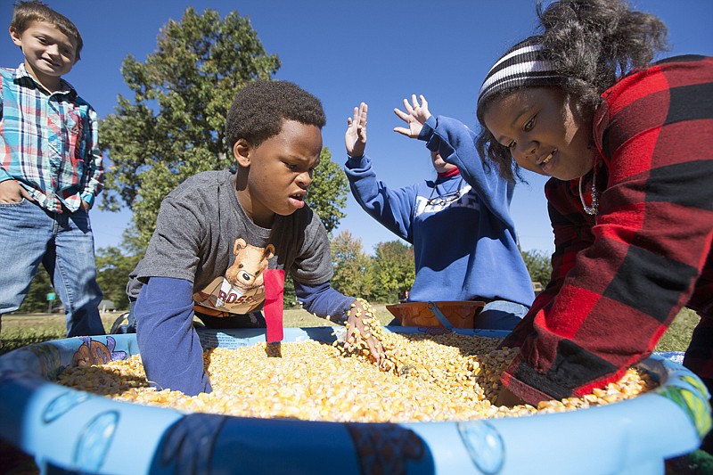 Fairview Elementary students Jacob Rhone and Ashlyn Turner search for gold coins and other prizes in a kiddie pool filled with kernels of corn on Wednesday at Buchanan First Baptist Church's Pumpkin Patch. This is the sixth year the church has held the community event. Buchanan First Baptist hosts about 1,100 preschool through second-grade students each year from Liberty-Eylau, Pleasant Grove, and Texarkana, Ark., school districts.  
