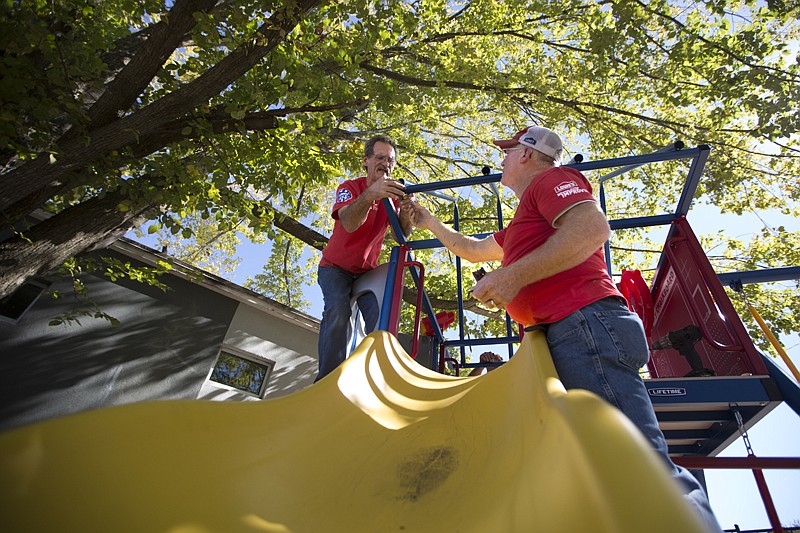 John Ray and others with the Lowe's Texarkana store install playground equipment Thursday at The Salvation Army Boys & Girls Club of Texarkana. Lowe's employees volunteer their time and expertise through Lowe's Heroes. The equipment and playground benches have a retail value of about $2,000.  