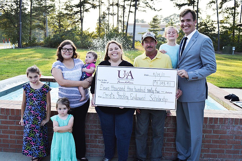 The family of Christa Shockley present a check for the establishment of the Christa Shockley Memorial Endowed Scholarship at the University of Arkansas at Hope-Texarkana. Pictured left to right: Samantha Shockley, sister; Kayleigh Shockley, sister; Tonya Shockley, sister; Alessa Penwell, niece; Eugenia Shockley, mother; James Shockley, father; Alaina Shockley, sister; and Chris Thomason, UA Hope-Texarkana chancellor.