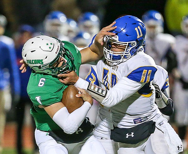 Blair Oaks quarterback Nolan Hair tries to escape the grasp of Wright City's Sean McDonald during Friday night's district semifinal game at the Falcon Athletic Complex in Wardsville.