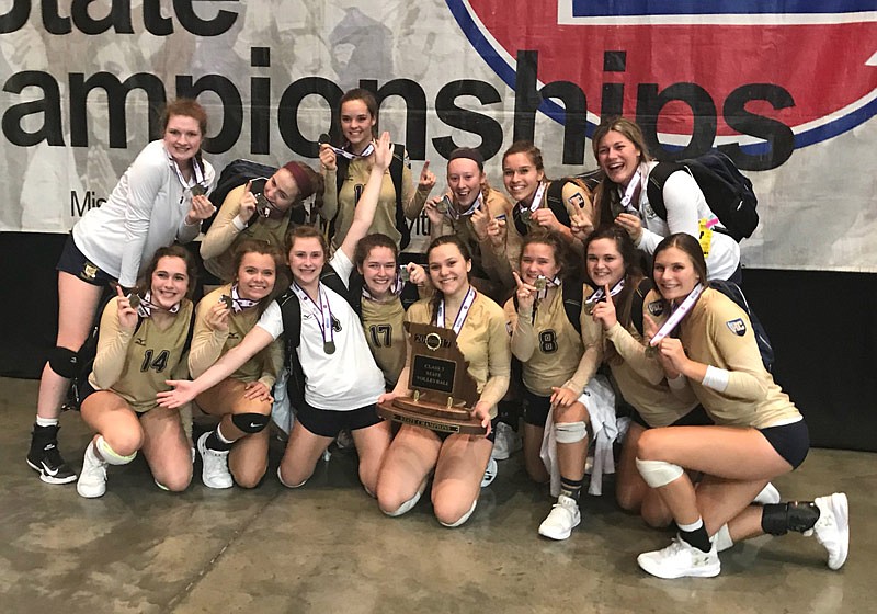 The Helias Lady Crusaders pose with the team's Class 3 state volleyball championship trophy.