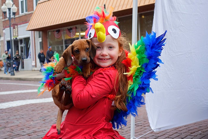 London Fountain, 5, poses with her puppy dog Oscar, in her parrot costume. She and her family joined in the Brick District's Halloween festivities Tuesday evening, Oct. 31, 2017 in downtown Fulton.