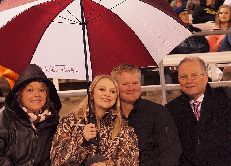 The umbrellas were out at Atlanta High's football game Friday, during which four alumni were named to the school's hall of fame. One was Max Sandlin, right, District 1 member of the U.S. House of Representatives from 1997 to 2005. With him, from left, are Jana Granberry and Sandlin's daughter, Emily Sandlin Fulbright, and husband Jacob Fulbright from Marshall, Texas.
