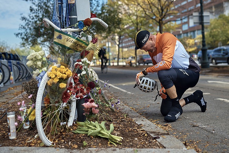 Eric Fleming, 41, stops by to express his condolences in front of a bike memorial where people leave flowers to remember the victims of the attack on Thursday, Nov. 2, 2017, in New York. A man in a rented pickup truck mowed down pedestrians and cyclists along the busy bike path near the World Trade Center memorial on Tuesday, killing at least eight and seriously injuring others in what the mayor called "a particularly cowardly act of terror." (AP Photo/Andres Kudacki)