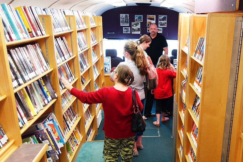 <p>Patrons browse the shelves of the Daniel Boone Regional Library Bookmobile in Auxvasse. The program is now in its 60th year. Driver Darin Fugit said the library tries to refresh the bookmobile’s stock frequently. (Helen Wilbers/FULTON SUN photo)</p>