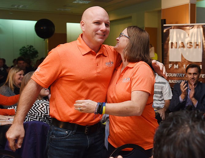 Jeff and Stacey DeLong, owners of Custom Screen Printing & Embroidery, hug each other Friday after being named the Small Business of the Year at the Jefferson City Area Chamber of Commerce's Small Business of the Year and Exceptional Employee luncheon at Capital Mall. Dana Davis, who works at the screen printing business, received the Exceptional Employee award.