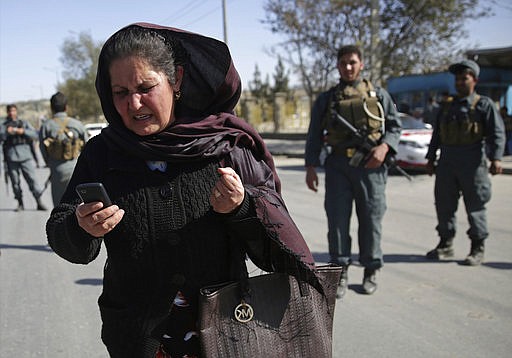 A mother tries to call her daughter who is stuck inside the Shamshad TV building after a deadly attack in Kabul, Afghanistan, Tuesday, Nov. 7, 2017. An Afghan official said a pair of attackers, one of them a suicide bomber, struck the local TV station and the Islamic State group quickly claimed responsibility for the assault.  (AP Photo/Massoud Hossaini)