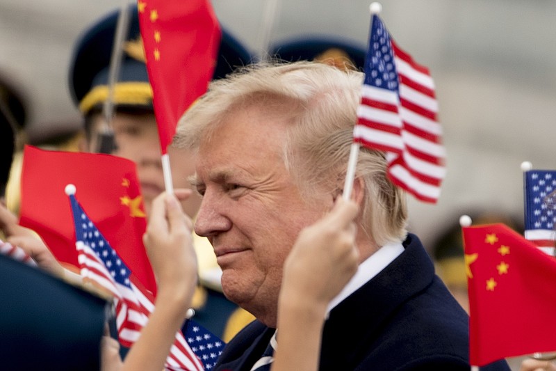 Children wave U.S. and Chinese flags as President Donald Trump arrives at Beijing Airport, Wednesday, Nov. 8, 2017, in Beijing, China. Trump is on a five country trip through Asia traveling to Japan, South Korea, China, Vietnam and the Philippines. (AP Photo/Andrew Harnik)