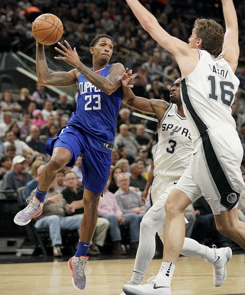 Los Angeles Clippers guard Lou Williams (23) looks to pass as San Antonio Spurs' Pau Gasol (16), of Spain, and Brandon Paul defend during the first half of an NBA basketball game, Tuesday, Nov. 7, 2017, in San Antonio.