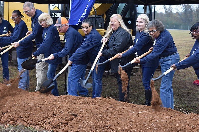 Ramona Sullivan helps break the ground during the ceremony Wednesday at the Nashville, Ark., Husqvarna plant. Sullivan and about 12 employees have worked more than 40 years at the plant broke ground for the construction of a 350,000-square-foot warehouse at the Nashville plant. 
