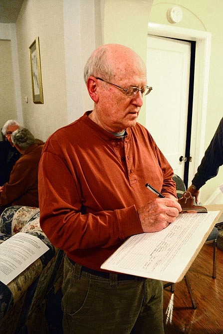 Tony Smith signs a sheet signaling his support Wednesday for designating the area between East McCarty, Lafayette and East Miller streets as a local historic district during a resident meeting at High Street Retreat.