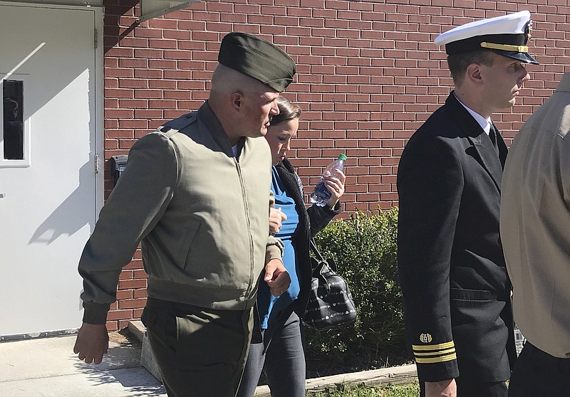 FILE - In this Oct., 31, 2017 file photo, U.S. Marine Gunnery Sgt. Joseph A. Felix, his wife, and his lawyers exit a courtroom after testimony at Camp Lejeune, N.C. A Marine Corps jury on Friday, Nov. 10,  is deciding whether Felix should be sentenced to military prison time for choking, punching and otherwise tormenting recruits, especially Muslims, one of whom eventually hurled himself to his death down a stairwell. The eight-man jury at Camp Lejeune, N.C., also could sentence  Felix to financial penalties and a dishonorable discharge. (Rory Laverty /The Washington Post/via AP, File)