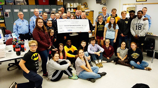 Members of Fulton Professional Firefighters Local 2945 and Fulton Student Council members and their advisor, Janet Trowbridge, got together Thursday to celebrate a donation to MDA. Through their shared Labor Day "Fill the Boot" drive, they raised $4,510