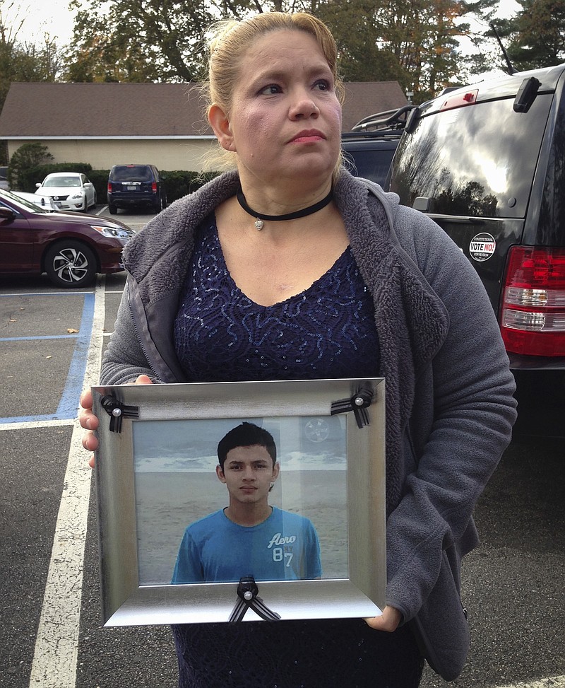 In this photo taken Wednesday, Nov. 8, 2017, in Brentwood, N.Y., Maria Lezema holds a photograph of her nephew, Javier Castillo. The FBI announced this week that Castillo's body was positively identified after his remains were found Oct. 24, in a park in Freeport, N.Y. Castillo, 16, of Central Islip, N.Y., had been reported missing more than a year earlier. Law enforcement authorities believe he may have been killed by the MS-13 street gang. (AP Photo/Frank Eltman).