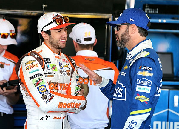 Chase Elliott (left) and Jimmie Johnson talk inside the garage area Friday before practice for the NASCAR Cup Series race at Phoenix International Raceway in Avondale, Ariz.