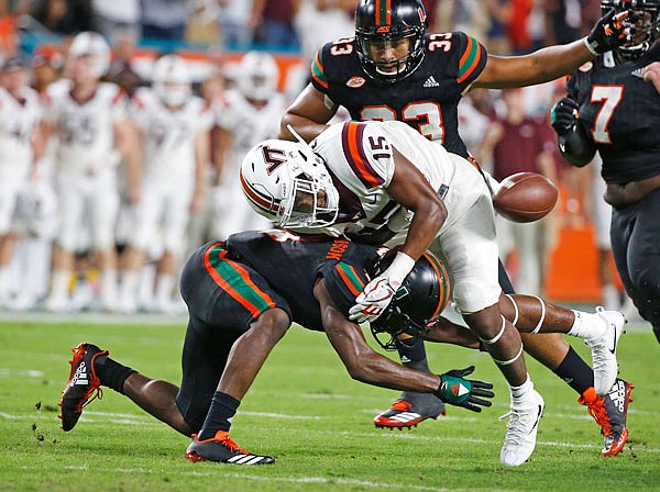 Miami defensive back Jaquan Johnson forces Virginia Tech wide receiver Sean Savoy to fumble during the first half of last Saturday night's game in Miami Gardens, Fla.