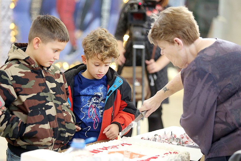 Nate Casey, 10, left, and Caiden Casey, 8, wait for pieces of a Salvation Army cake Saturday during the kick off party for the Salvation Army's Red Kettle Campaign at the Capital Mall.