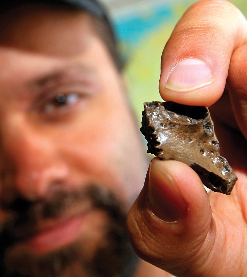 Derek Main shows off part of a jawbone of a baby prehistoric crocodile fossil he and his group found at the Arlington Archosaur Site in North Arlington, Texas.