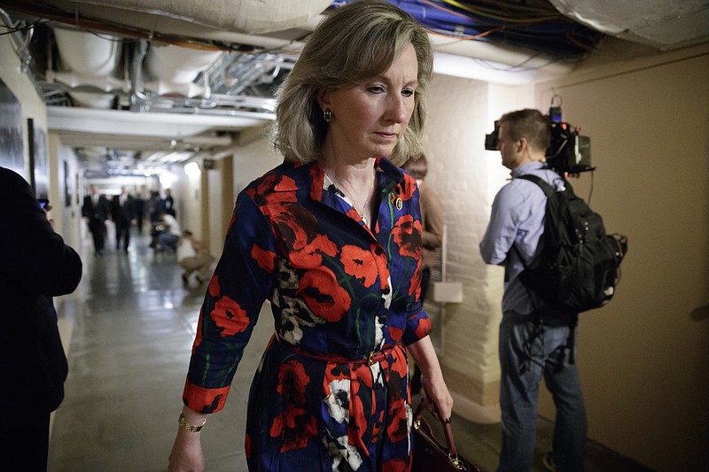 FILE - In this March 28, 2017, file photo, Rep. Barbara Comstock, R-Va., walks at the Capitol, in Washington. Amid a daily deluge of stories about harassment in the workplace, female members of Congress detailed incidents of sexual misconduct involving current lawmakers at a House hearing on how to prevent such abuse. Comstock said she was recently told about a staffer who quit her job after a lawmaker asked her to bring work material to his house, then exposed himself. (AP Photo/J. Scott Applewhite, File)