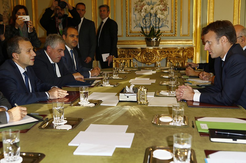 Lebanese Foreign Minister Gebran Bassil, left, and French President Emmanuel Macron, right, attend a meeting at the Elysee Palace, in Paris, Tuesday Nov. 14, 2017. (AP Photo/Francois Mori, Pool)