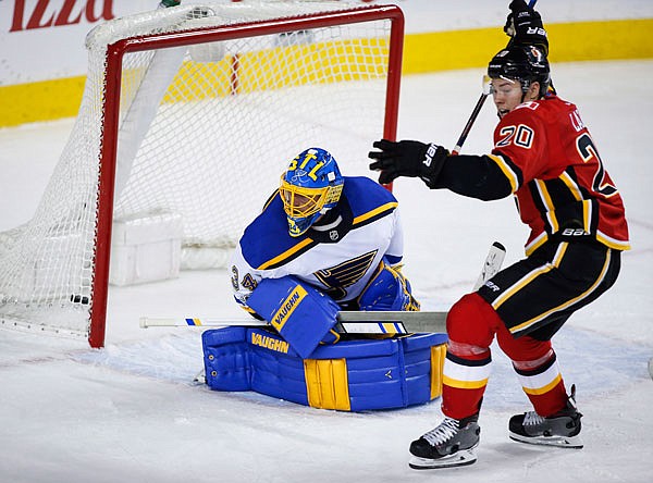 Blues goalie Jake Allen left looks back as Curtis Lazar of the Flames celebrates his team's goal during the third period of Monday night's game in Calgary, Alberta.