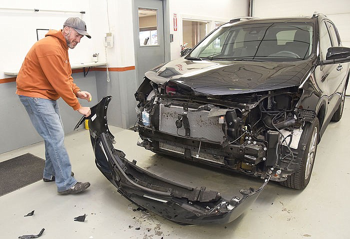 Jim Canaday removes the front cover from this vehicle after it was taken to Kemna Collision Center in Wardsville for repair. Canaday is an auto body technician and has seen numerous automobiles this fall due to car-deer collisions.