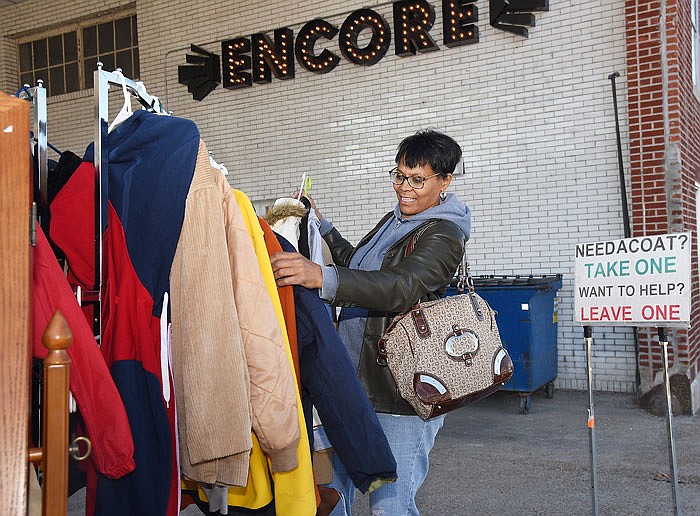 Mica Turner selects some coats to take to residents of the Salvation Army Center of Hope, where she currently resides. 
Annie Schulte, owner of Encore Department Store at the corner of Adams Street and East Capitol Avenue, recently placed a clothing rack in front of her store with a sign reading "Need A Coat? Take One, Want To Help? Leave One." The rack stayed outside all weekend, and it and the coats remained.