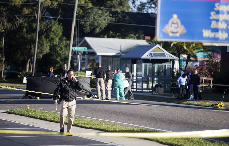 Law enforcement agents investigate a fatal shooting in the Seminole Heights neighborhood in Tampa, Fla., Tuesday, Nov. 14, 2017. Police searched the neighborhood after a person was shot dead, possibly by a serial killer. Spokesman Steve Hegarty said detectives can't immediately say whether the shooting is related to last month's 10-day spree where three people were slain, but officers are treating it like it is. (Jones, Octavio/Tampa Bay Times)