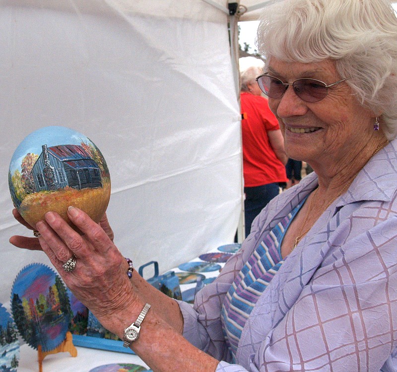 Artist Nancy Hollis of Texarkana carefully holds the emu egg she has painted and is showing at the recent Cullen Baker Country festival.