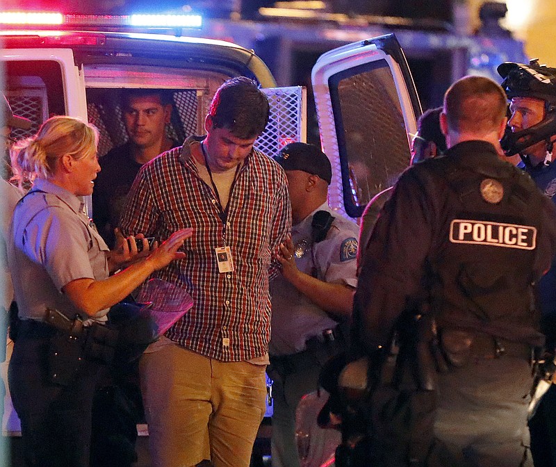 In this Sunday, Sept. 17, 2017 photo, St. Louis Post-Dispatch reporter Mike Faulk, second from left, is placed in the back of a police van after being arrested while covering protests in response to a not guilty verdict in the trial of former St. Louis police officer Jason Stockley in St. Louis. St. Louis police officers will be required each month to read and acknowledge an order reiterating the rights of journalists. The move comes after the St. Louis Post-Dispatch met with city and police officials to discuss officer-journalist relationships (AP Photo/Jeff Roberson)