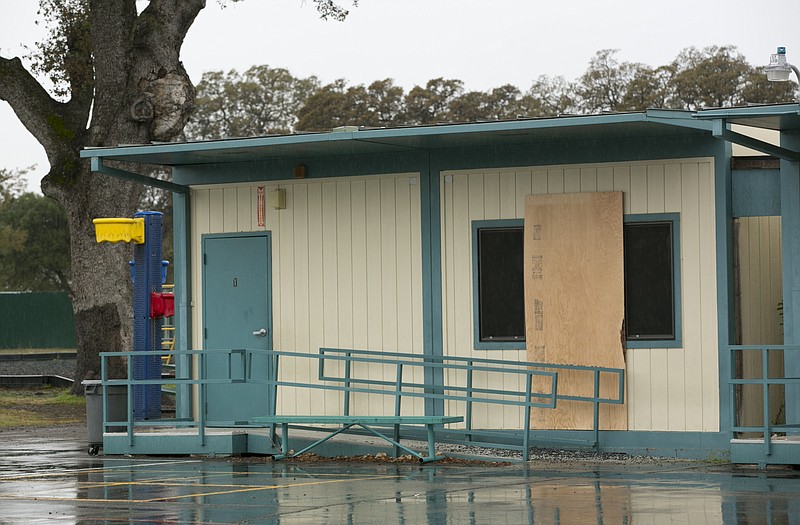 Plywood covers one of the windows at the Rancho Tehama Elementary School, Wednesday, Nov. 15, 2017, that was shot out during gunman Kevin Janson Neal's shooting rampage at Rancho Tehama Reserve, Calif., Tuesday. Neal killed five people, including his wife before being shot and killed by Tehama County Sheriff's deputies. Neal is believed to have spent six minutes shooting into the school before driving off to continue his shooting spree. One student was shot but is expected to survive. (AP Photo/Rich Pedroncelli)