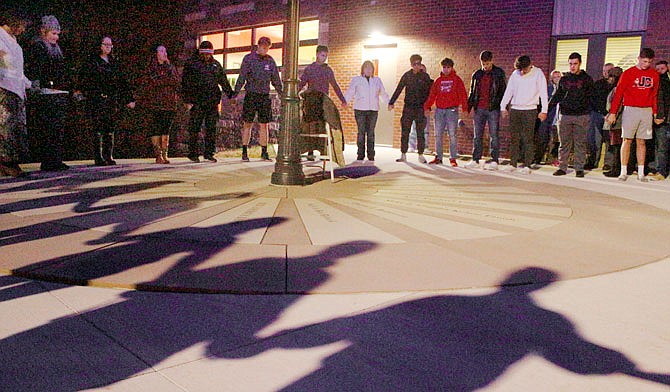 Concerned friends, family and classmates gather in a prayer circle Thursday during a vigil for missing teens Zachary Johnson, 15, and Lilly Gore, 17, at the Boys & Girls Club. Both teens have been missing since Monday.  