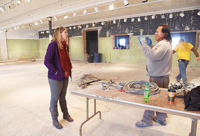 Ashley Varner, left, discusses the setup for the future Indoor Capital City Farmers Market with Spottedwolves Spirit. The market will be located in the former Milo Walz and Blattner Furniture building at 704 Madison St. Spirit is part of a crew demolishing the building's interior.