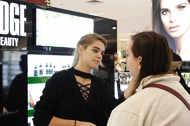 Cassie Mitchell, Edge business manager from Tulsa, Okla., applies makeup to Shelby Campell during the Dillard's grand reopening Thursday morning at Central Mall in Texarkana, Texas. Dillard's added 42,000 square feet of space and brought many new, premium brands to the store, with the expansion including a larger, interactive cosmetics section.