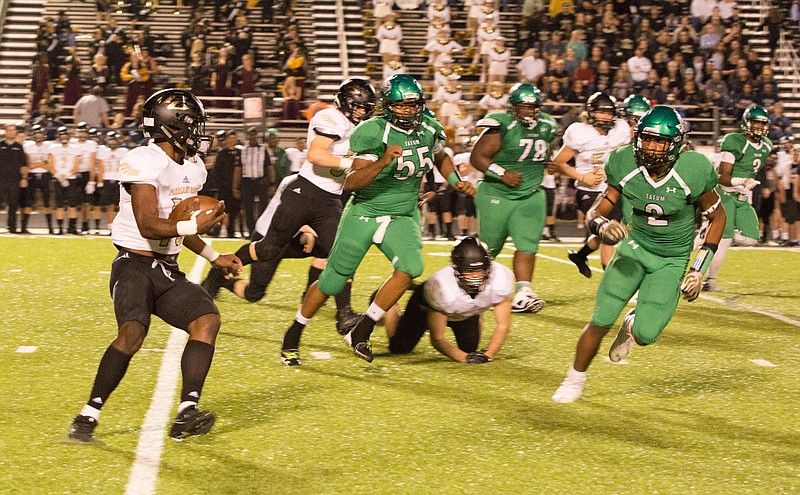 Pleasant Grove fullback TJ Cole runs around the right end while being chased by Tatum defenders on Friday at Eagle Stadium. The Hawks won the Class 4A, Division II bi-district game, 21-7, over the Eagles. (Photo courtesy of Longview News-Journal)
