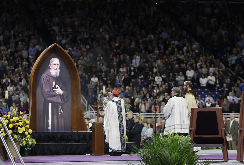 Cardinal Angelo Amato blesses a portrait of Father Solanus during Mass of the Beatification Ceremony, Saturday, Nov. 18, 2017, in Detroit. A priest who wasn't allowed to preach instead turned his ears and heart to the needy. Now, decades after his death, Solanus Casey is on a path to sainthood, celebrated as an incredibly humble man who brought people to God. (AP Photo/Carlos Osorio)