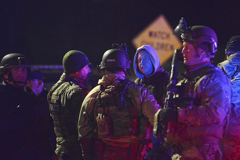 SWAT team members prepare to search the neighborhood where a police officer was fatally shot Friday, Nov. 17, 2017, in New Kensington, Pa. Authorities in Pennsylvania say a police officer was shot and killed while making a traffic stop and a search is underway for the gunman. (Rebecca Droke/Pittsburgh Post-Gazette via AP)