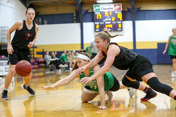 Gretta Haarmann of the Lady Jays battles Hunter Lauf of Blair Oaks for a loose ball Friday night at Helias.