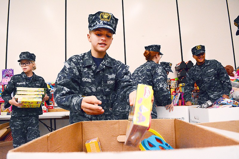 Josh Moore puts a toy inside a box Saturday before loading it into a truck at Thomas Jefferson Middle School. The Toys for Tots event was held by the Society for Creative Anachronism, and the toys are to be given to needy children in Cole County and the surrounding area.