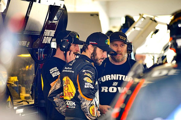 Martin Truex Jr. looks at his car alongside his crew during practice for today's NASCAR Cup Series race at Homestead-Miami Speedway in Homestead, Fla.