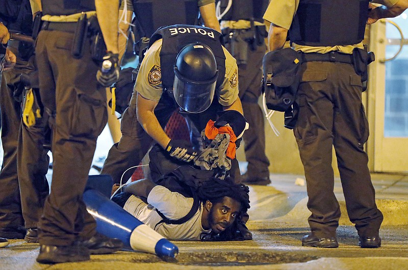 In this Sept. 17, 2017, file photo, police arrest a man as people protest a not guilty verdict in the trial of former St. Louis police officer Jason Stockley, in St. Louis. (AP Photo/Jeff Roberson, File)